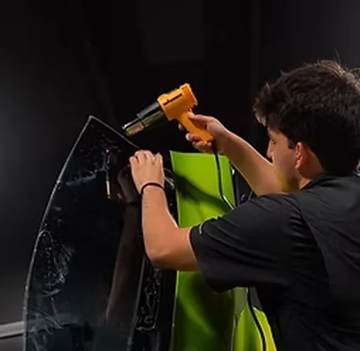 A heat gun shrinking film onto curved glass