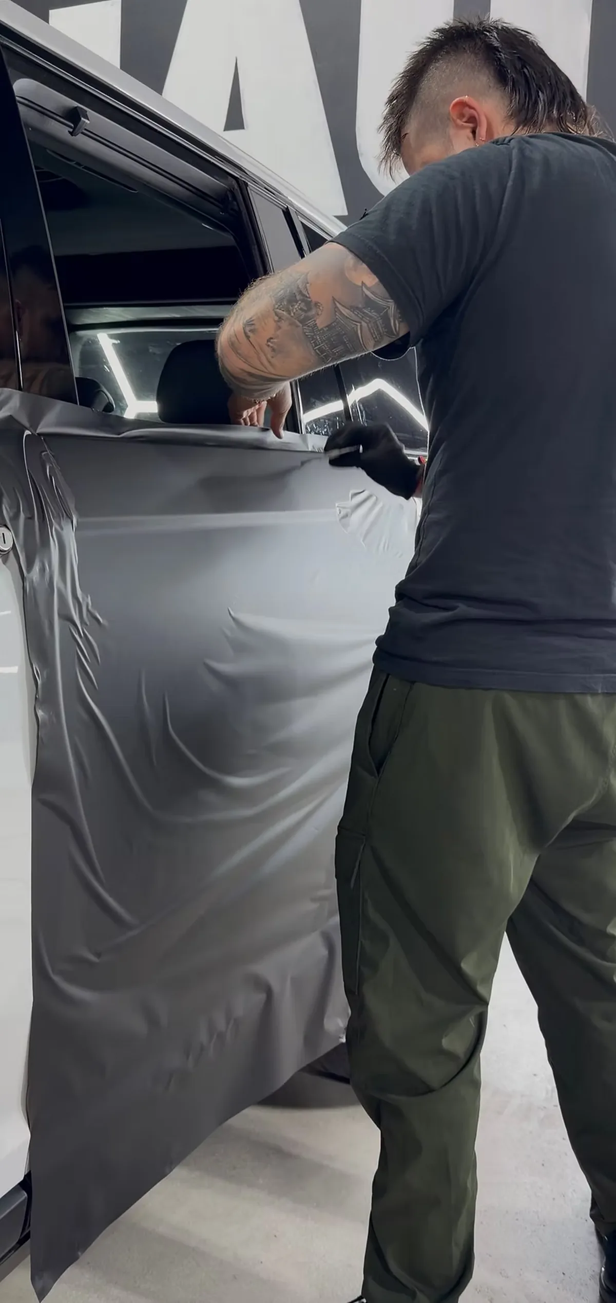 An installer working film into a door panel