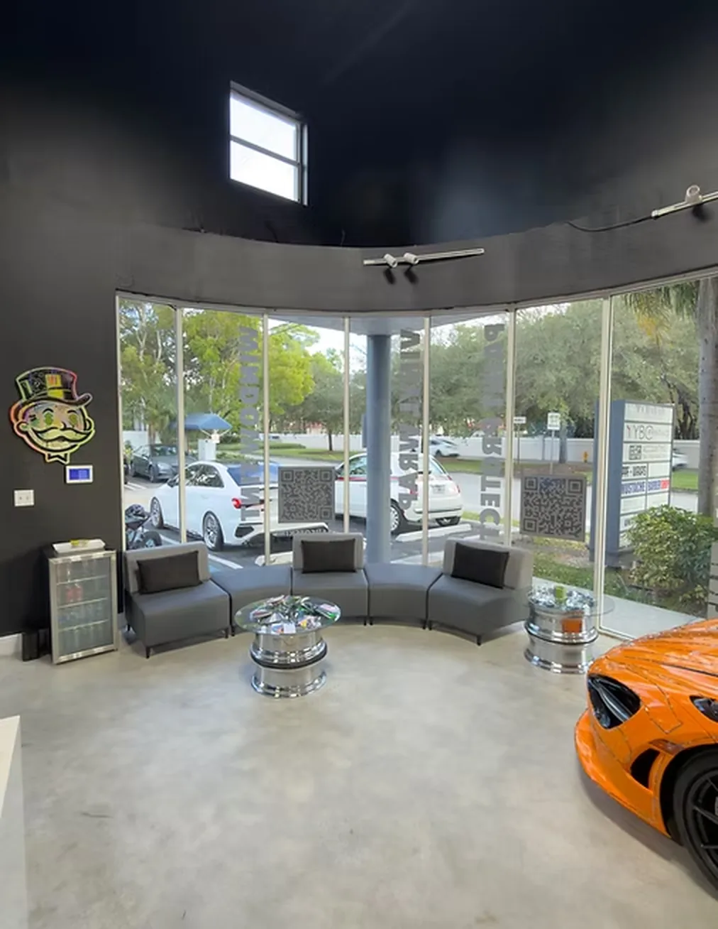The customer lounge inside the shop, with a car visible through the glass